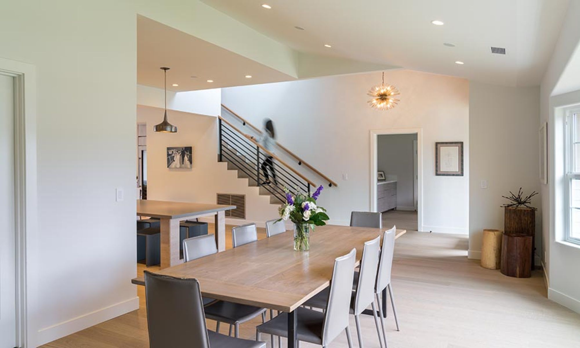 Bright dining room and staircase with natural light and minimalist pendant lamp