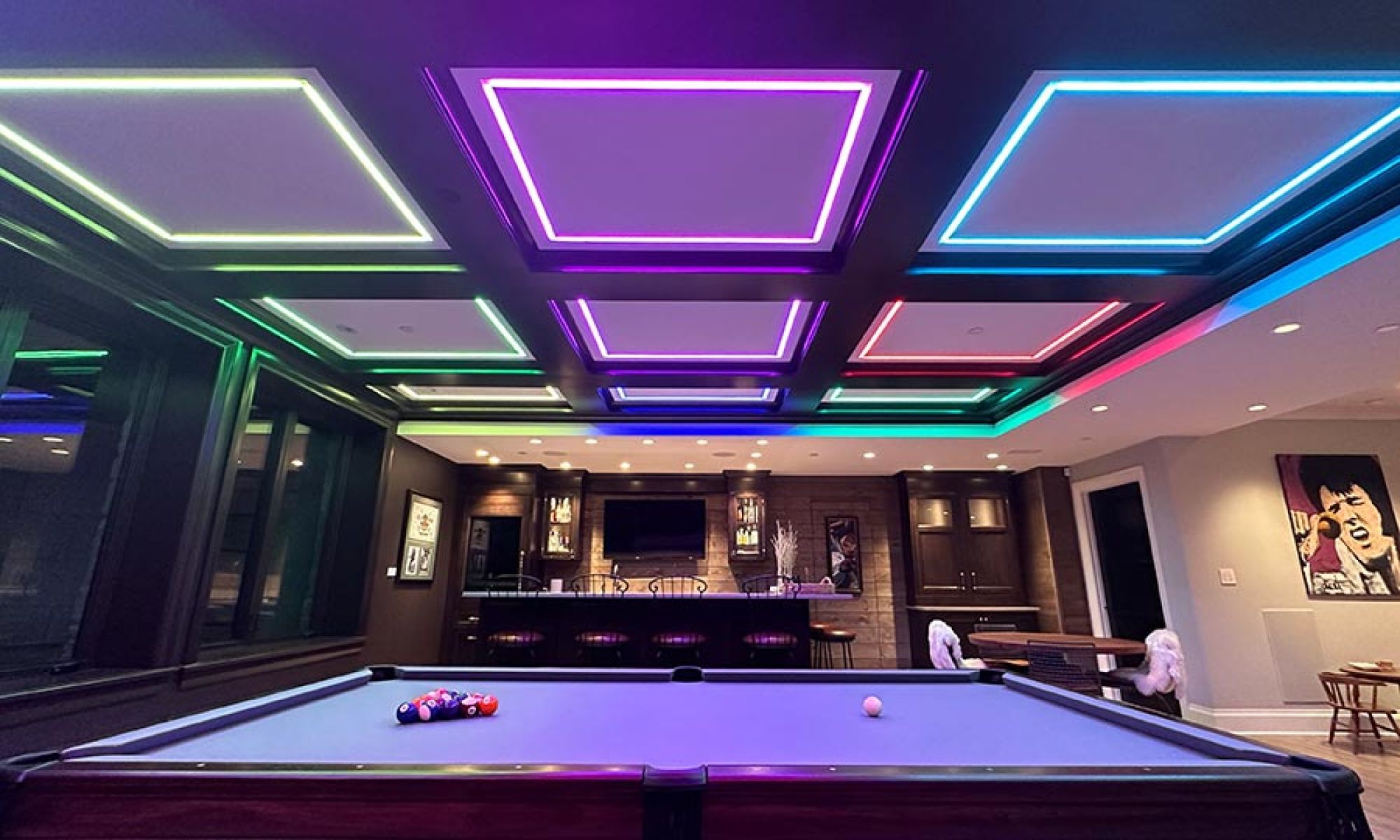 Game room with a pool table and colorful neon square ceiling lighting